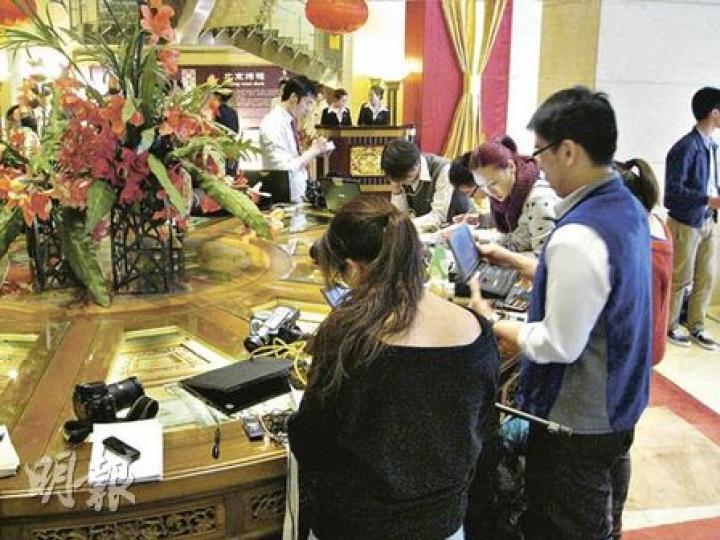北京飯店電梯大堂中有一張圓形的裝飾枱，昨日被大批港澳記者當作辦公枱。（陳小強攝）