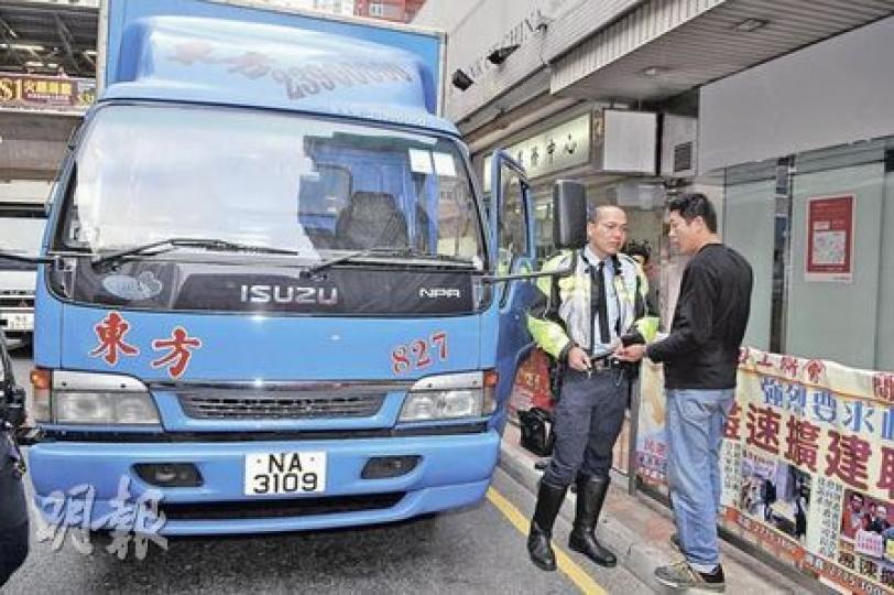 電召貨車司機（黑色上衣）接獲警方聯絡，返回啟田道車禍現場接受調查，對女途人被汽車撞倒一事表示「唔知」。（衛永康攝）
