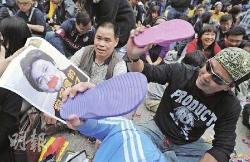 香港人網昨於遮打道行人專用區，舉辦千人打小人集會，參與市民以財政司長曾俊華作打擊目標，以拖鞋拍打絕不留手。（劉焌陶攝）