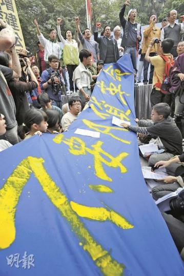 「80後城市青年」刻意在民主黨議員站台時，拉起「不要A貨革命」橫額，並在台上眾人高呼「曾俊華無恥」時，大喊「民主黨無恥」。 （朱永倫攝）