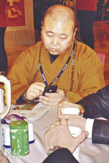 手持iPhone4的上海玉佛禪寺覺醒住持稱，佛教也要與時俱進。（王艷喆攝）
