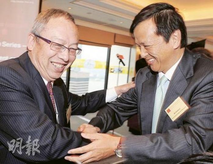 曾任聯交所行政總裁、現任香港華高和升財務顧問有限公司主席的徐耀華（左），與港交所總裁李小加（右）昨日碰面，兩人惺惺相惜，熱情地握手打招呼。（劉焌陶攝）