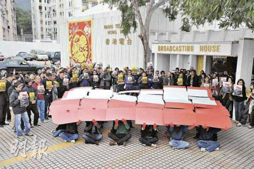 數十港台員工在廣播大樓外集會，高叫口號，並以紙板砌出沒有「香港港台」字眼的港台標誌，要求當局不要令港台淪為空殼。（何家達攝）