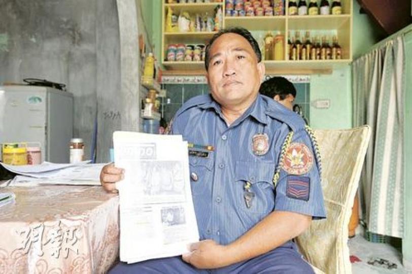 本身亦是警察，現被停職的格雷戈里奧，昨日穿好警服戴上襟章接受訪問，向記者展示兄長門多薩當年破案亦沒有中飽私囊的報道。（葉漢華攝）