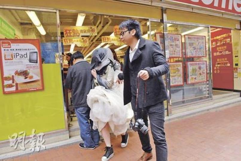 尖沙嘴金巴利道一婚紗店發生火警，一名穿著婚紗的準新娘狼狽逃生，準新娘為躲避傳媒採訪，更跑到對面超級市場。（梁琬珊攝）