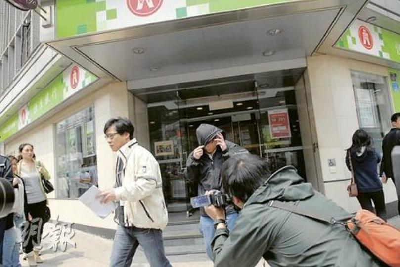 遇劫男子（右，面向鏡頭者）在九龍城福佬村道銀行提取44萬元現金，聲稱準備買樓，甫步出銀行即遭兩名劫匪搶走。（屈俊樂攝）劫匪強搶裝有44萬元的公文袋，糾纏間有數千元鈔票散落地上，目擊劫案的男子（圖）拾起鈔票交給銀行。（屈俊樂攝）