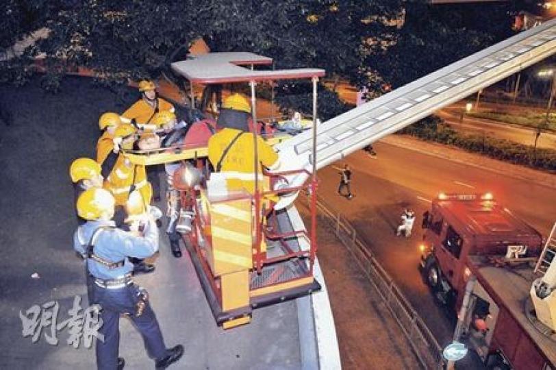 醉漢在亞皆老街天橋頂拾手機後無法離開，需勞動消防員到場升起雲梯拯救。（蔡方山攝）醉漢在亞皆老街天橋躍下螺旋行人天橋頂（箭嘴示）撿拾電話，其後卻未能返回安全地方，要由消防救回地面。（蔡方山攝）