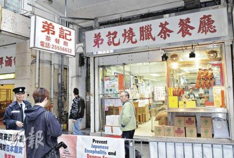 香港仔田灣街「弟記燒臘茶餐廳」遇竊，警方接報派員到場調查，證實店方損失1萬多元現金。（蔡方山攝）香港仔田灣街茶餐廳被爆竊，店舖收銀處貼有一張最後一任港督彭定康巡視華貴邨時與老闆握手的相片。（蔡方山攝）