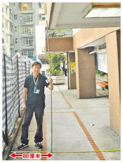 反興建美孚屏風樓小組召集人葉少舟，以拉尺展示新地盤圍網與8期露台之間只相隔80厘米。（葉漢華攝）