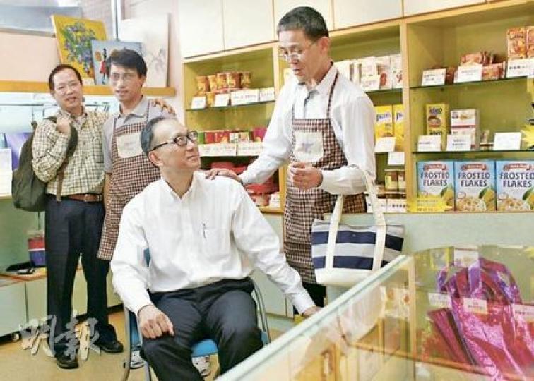 手袋廠老闆梁志文（左一）、食物商呂可翹（右二），這兩個中小企老闆3年來不斷向盲人輔導會商店捐貨或以成本價供貨，令店舖成為培訓失明零售員（戴圍裙者）的平台，賺得利潤兩人都不落袋，更義務擔任營商顧問提供生意貼士，目標為盲人在職場開拓新路。（林振東攝）梁志文捐出他生產的名牌手袋，讓盲人輔導會ES店以84元特惠價出售，吸引石硤尾街坊選購。（林振東攝）