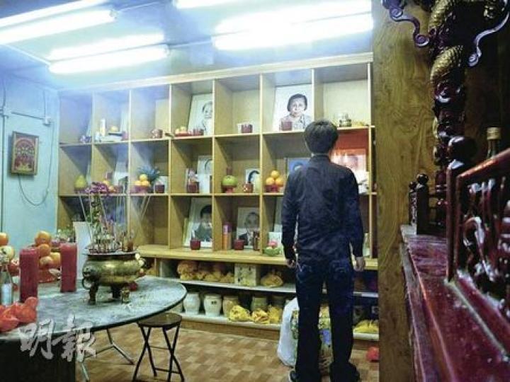 中盛殯儀閣樓改裝成的小型臨時龕場，龕位是以木架分隔，負責人稱場內禁燒蠟燭，但昨日現場所見，有孝子賢孫並無理會，仍燃點蠟燭拜祭先人。 （明報記者攝）