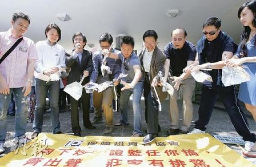 遊行人士借撕破「鑊鏟」，抗議當局漠視市場日益嚴重的「向下炒」活動。（林振東攝）
