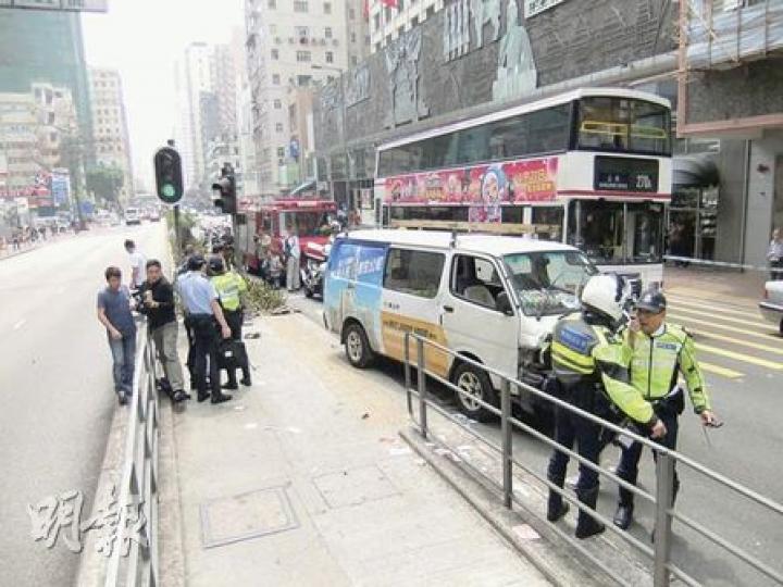 客貨車剷上路邊花槽，撞毁安全島鐵欄及行人後，扭軚駛出路面。（黃雄攝）救護員即場為被客貨車撞傷男子施救，消防員亦撐傘替傷者遮擋太陽。（黃雄攝）肇事客貨車司機（左二）事後在場等候警方調查。（黃雄攝）