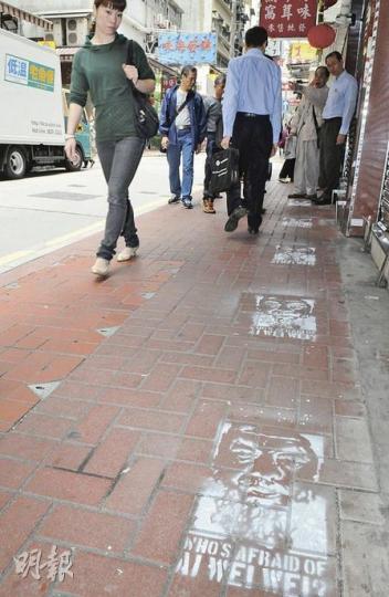 上環永樂街行人路被人噴上艾未未肖像，附有字句「WHO'S AFRAID OF AI WEI WEI」，途人為之側目。（蔡方山攝）