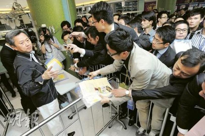 為營造「尚城」售樓處的氣氛熾熱，長實執行董事趙國雄（左）親自向代理們「派貨」。（尹錦恩攝）（明報製圖）