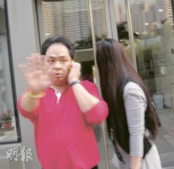 被告王滿華（圖）昨在庭外避開記者拍攝。他多次央求法庭歸還手機，被署任主任裁判官陳錦昌指他「做乜咁長氣」。（林景輝攝）女被告周結紅亦不斷逃避記者拍攝，又說︰「做乜影我呀？信唔信告你﹗」（林景輝攝）