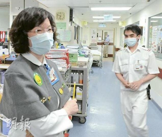 醫管局關閉護士學校，但大學培訓的護士不足應付需求，伊利沙伯醫院內科病房經理（穿灰短褸）慨嘆護士不足夠，要聘請其他部門的護士兼職（白衣白褲）。政府同意今年繼續開辦護士學校，紓緩護士人手。（劉焌陶攝）