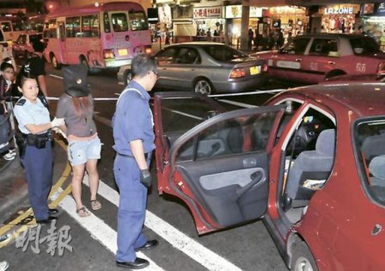 警員截停涉案私家車搜查，在司機位底下檢獲800克K仔，女司機被捕，黑布蒙頭帶署。（林錫禮攝）