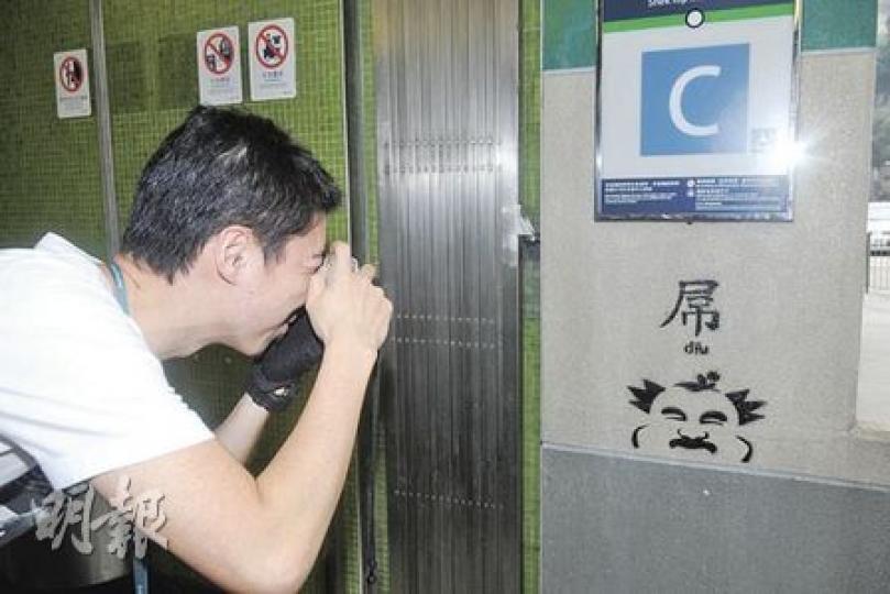 警員在石硤尾港鐵站C出口調查新發現的塗鴉。(蔡方山攝) 警員在石硤尾港鐵站C出口調查新發現的塗鴉。(蔡方山攝)