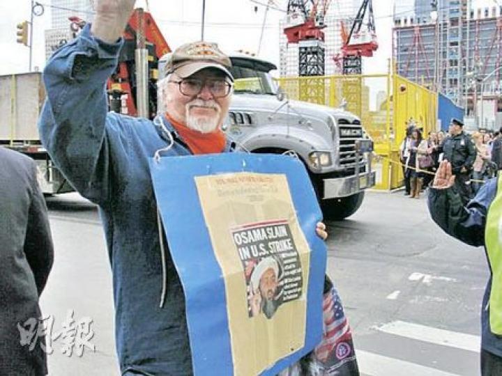 美國人比爾昨在世貿中心遺址外慶祝拉登死亡。他認為,紐約未來一周可能陷入危險中,但他說:「我們不可生活在惶恐之中,這正正是恐怖分子的目的。」(明報特約記者攝) 美國人比爾昨在世貿中心遺址外慶祝拉登死亡。他認為,紐約未來一周可能陷入危險中,但他說:「我們不可生活在惶恐之中,這正正是恐怖分子的目的。」(明報特約記者攝)