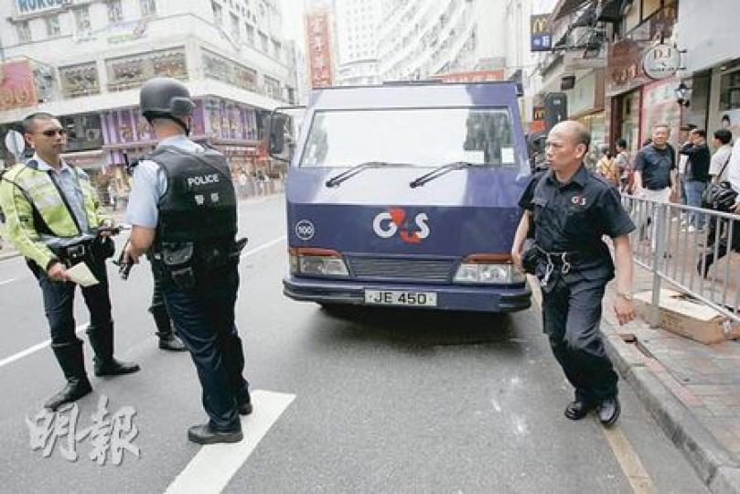 解款車司機(右)往如廁期間被車撞傷,事後回解款車收拾個人物品後送院。荷槍實彈警員(左)到場以防有人趁火打劫。(黃雄攝) 解款車司機(右)往如廁期間被車撞傷,事後回解款車收拾個人物品後送院。荷槍實彈警員(左)到場以防有人趁火打劫。(黃雄攝)