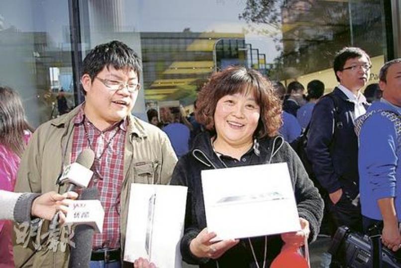 經16個小時通宵排隊的俞虹(右)和兒子終於買到兩部iPad2後,展示「戰利品」。(王艷喆攝) 經16個小時通宵排隊的俞虹(右)和兒子終於買到兩部iPad2後,展示「戰利品」。(王艷喆攝)