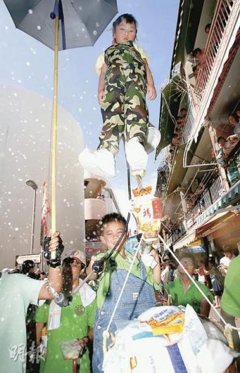 只得5歲的梁晞樂(上)這天扮演日本防輻射人員,原定要戴上眼罩,沿途噴灑「輻射水」,不過未知是否因臨行前跌了放在口邊的雪條,「未出發,先大哭」,要由下方的環保大使代勞灑水,但他卻毫不介意,還樂在其中,連呼「好好玩」。其身旁則有一籃食鹽,暗諷市民「盲搶鹽」,以為能抗輻射。(林振東攝)飄色「一旨(意指政策)錯」同樣把派錢事件擺上飄色台上,負責設計的長洲惠海陸同鄉會飄色司庫黃成就透露,用了一個月時間構思,上面一前一後分別站着議員和高官,議員(前)腳踏苦瓜、番薯、冷飯菜汁,為下方縛上紙皮鐵罐、橫揹掃帚的低 只得5歲的梁晞樂(上)這天扮演日本防輻射人員,原定要戴上眼罩,沿途噴灑「輻射水」,不過未知是否因臨行前跌了放在口邊的雪條,「未出發,先大哭」,要由下方的環保大使代勞灑水,但他卻毫不介意,還樂在其中,連呼「好好玩」。其身旁則有一籃食鹽,暗諷市民「盲搶鹽」,以為能抗輻射。(林振東攝)飄色「一旨(意指政策)錯」同樣把派錢事件擺上飄色台上,負責設計的長洲惠海陸同鄉會飄色司庫黃成就透露,用了一個月時間構思,上面一前一後分別站着議員和高官,議員(前)腳踏苦瓜、番薯、冷飯菜汁,為下方縛上紙皮鐵罐、橫揹掃帚的低