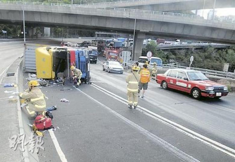 一輛拖着40呎長貨櫃的貨櫃車在呈祥道翻側,消防即場為受傷司機治理傷勢。車廂雜物散落馬路,大量柴油漏出,現場交通嚴重受阻。(蔡方山攝)消防員即場在路邊為貨櫃車司機治理傷勢。(蔡方山攝) 一輛拖着40呎長貨櫃的貨櫃車在呈祥道翻側,消防即場為受傷司機治理傷勢。車廂雜物散落馬路,大量柴油漏出,現場交通嚴重受阻。(蔡方山攝)消防員即場在路邊為貨櫃車司機治理傷勢。(蔡方山攝)