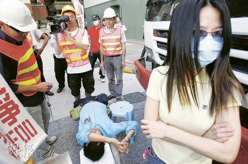 美孚居民昨日以身軀阻止工程車駛進地盤,地盤工人則以攝錄機及相機在旁記錄,大部分居民戴上口罩,以免樣貌被拍下。 (林振東攝) 美孚居民昨日以身軀阻止工程車駛進地盤,地盤工人則以攝錄機及相機在旁記錄,大部分居民戴上口罩,以免樣貌被拍下。 (林振東攝)