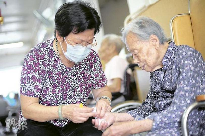 最低工資令私營安老院舍難請人,有院舍只能聘請長者照顧院友。69歲的珠姐(左)是安慈護理之家內最老的護理員,雖然早屆退休年齡,她同樣要幫院友剪指甲、餵飯、換片等。(何家達攝) 最低工資令私營安老院舍難請人,有院舍只能聘請長者照顧院友。69歲的珠姐(左)是安慈護理之家內最老的護理員,雖然早屆退休年齡,她同樣要幫院友剪指甲、餵飯、換片等。(何家達攝)