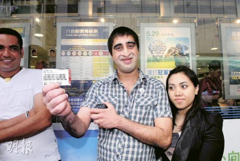 「幸運Singh」高興地展示中獎彩票,女友在旁緊緊倚靠愛郎,眼中卻盯着他手中彩票。(雲錦鋒攝) 「幸運Singh」高興地展示中獎彩票,女友在旁緊緊倚靠愛郎,眼中卻盯着他手中彩票。(雲錦鋒攝)