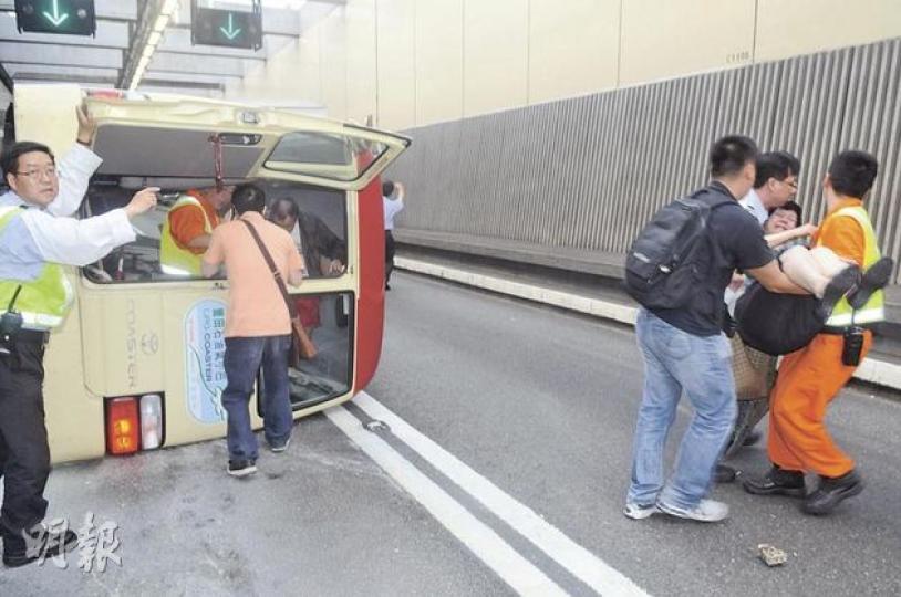 紅頂小巴在紅隧入口遇事翻側,冒出大量濃煙,隧道職員從小巴車尾的太平門將乘客逐一救出。(蔡方山攝)多名小巴乘客互相攙扶由車內爬出,坐在隧道旁石壆,傷勢較重者躺在路邊等候救援。(蔡方山攝) 紅頂小巴在紅隧入口遇事翻側,冒出大量濃煙,隧道職員從小巴車尾的太平門將乘客逐一救出。(蔡方山攝)多名小巴乘客互相攙扶由車內爬出,坐在隧道旁石壆,傷勢較重者躺在路邊等候救援。(蔡方山攝)