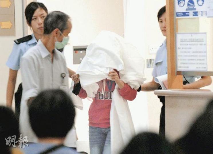 女傭(用布蒙頭者)事後自行往醫院求醫時遭揭發事件,被警方以「非法墮胎」罪名拘捕。(屈俊樂攝) 女傭(用布蒙頭者)事後自行往醫院求醫時遭揭發事件,被警方以「非法墮胎」罪名拘捕。(屈俊樂攝)