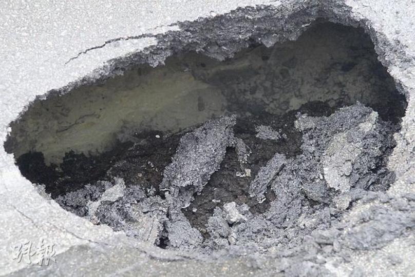 華富道路面瀝青破裂下陷,坑洞面積約1米乘半米,被困的士意外後電召拖車拖回路面,稍後驅車離去。(梁琬珊攝) 華富道路面瀝青破裂下陷,坑洞面積約1米乘半米,被困的士意外後電召拖車拖回路面,稍後驅車離去。(梁琬珊攝)
