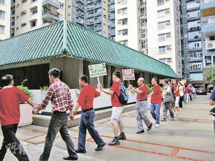 參加行動的美孚居民手牽手,圍繞孚佑堂行走三圈,代表要保護這座擁30多年歷史的社區會堂。(梁杏怡攝) 參加行動的美孚居民手牽手,圍繞孚佑堂行走三圈,代表要保護這座擁30多年歷史的社區會堂。(梁杏怡攝)