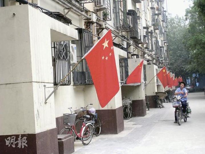 北京市區居民區近日起每個樓道門口都懸掛了國旗,營造紅色喜慶氣氛。(明報記者攝) 北京市區居民區近日起每個樓道門口都懸掛了國旗,營造紅色喜慶氣氛。(明報記者攝)