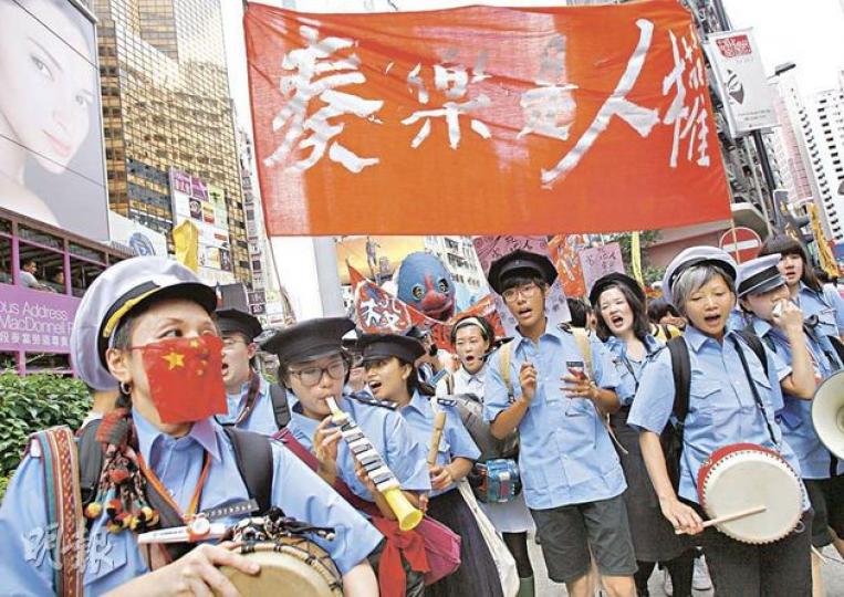 藝術公民成員穿起「公安服」,沿途吹奏各種樂器及打鼓,以表達不滿警方一度禁止遊行奏樂的規限。(林振東攝) 藝術公民成員穿起「公安服」,沿途吹奏各種樂器及打鼓,以表達不滿警方一度禁止遊行奏樂的規限。(林振東攝)