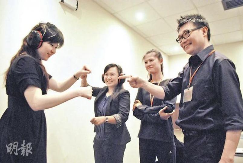 「無聲對話」體驗坊要求參加者戴耳筒體驗做聾人，合力完成挑戰，例如合演短劇。聾人導師Keith（右一）和Connie（右二）在旁指導。參加者需在無聲環境下，發掘言語以外的溝通方式。（阮穎嘉攝）
