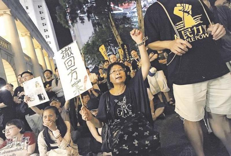 政團一連3日包圍立法會的行動今日是高潮,人民力量聲言會向出席答問大會的特首曾蔭權投擲紙飛機,並會試圖阻止他離開。昨晚第二日的集會(圖),參與者只高呼口號及唱歌,要求政府撤回遞補方案,晚上約10時便和平散去。(余俊亮攝)(明報製圖) 政團一連3日包圍立法會的行動今日是高潮,人民力量聲言會向出席答問大會的特首曾蔭權投擲紙飛機,並會試圖阻止他離開。昨晚第二日的集會(圖),參與者只高呼口號及唱歌,要求政府撤回遞補方案,晚上約10時便和平散去。(余俊亮攝)(明報製圖)