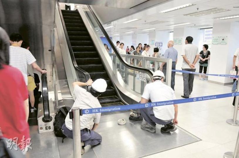 灣仔入境大樓扶手電梯冒煙，技工事後檢查相關電梯。（林錫禮攝）