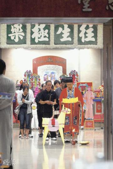 黎氏三母子昨晚在紅磡萬國殯儀館設靈，靈堂上掛上母子合照，以及特製紙紮木馬等祭品。（鍾炳然攝）
