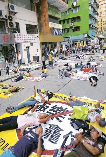 各界關注骨灰龕法案大聯盟昨在紅磡老龍坑街一帶的行車路「瞓街」,抗議政府縱容違規龕場,並促請當局盡快立法監管。(林振東攝) 各界關注骨灰龕法案大聯盟昨在紅磡老龍坑街一帶的行車路「瞓街」,抗議政府縱容違規龕場,並促請當局盡快立法監管。(林振東攝)