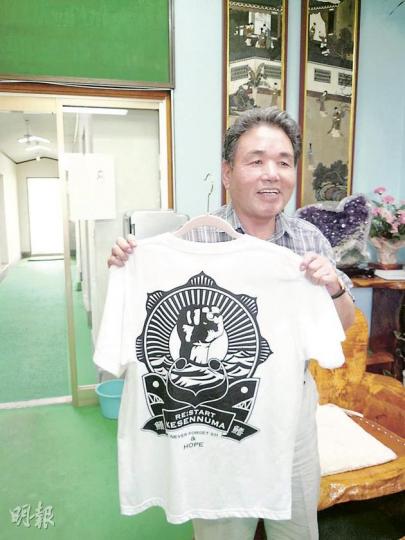 石渡正師(上圖)為籌集資金重建工場出盡法寶,公司亦印製了一批為氣仙沼打氣的T恤出售。(林康琪攝)大船渡市長戶田公明展示中國救援隊送贈的紀念品,他表示感謝救援隊。(林康琪攝) 石渡正師(上圖)為籌集資金重建工場出盡法寶,公司亦印製了一批為氣仙沼打氣的T恤出售。(林康琪攝)大船渡市長戶田公明展示中國救援隊送贈的紀念品,他表示感謝救援隊。(林康琪攝)