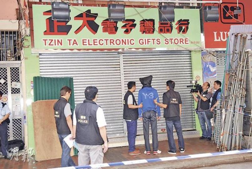 其中一名逾6呎高的疑犯被黑布蒙頭、鎖上手銬,帶到案發店舖重組案情。(梁琬珊攝) 其中一名逾6呎高的疑犯被黑布蒙頭、鎖上手銬,帶到案發店舖重組案情。(梁琬珊攝)