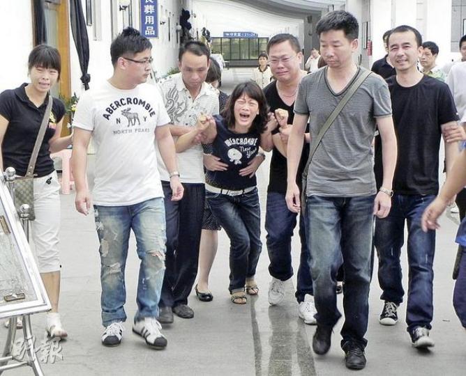 死者陳鴻鵬的母親(中)進入靈堂看到兒子遺容後悲傷欲絕,幾欲昏倒,要由親友攙扶,最後需親友將她抱離殯儀館。(李泉攝) 死者陳鴻鵬的母親(中)進入靈堂看到兒子遺容後悲傷欲絕,幾欲昏倒,要由親友攙扶,最後需親友將她抱離殯儀館。(李泉攝)
