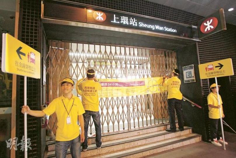 為進行西港島線工程,上環站昨深夜11時30分起封閉54小時,有工作人員手持指示牌,着往金鐘站的乘客,可轉乘免費接駁巴士。(林振東攝) 為進行西港島線工程,上環站昨深夜11時30分起封閉54小時,有工作人員手持指示牌,着往金鐘站的乘客,可轉乘免費接駁巴士。(林振東攝)