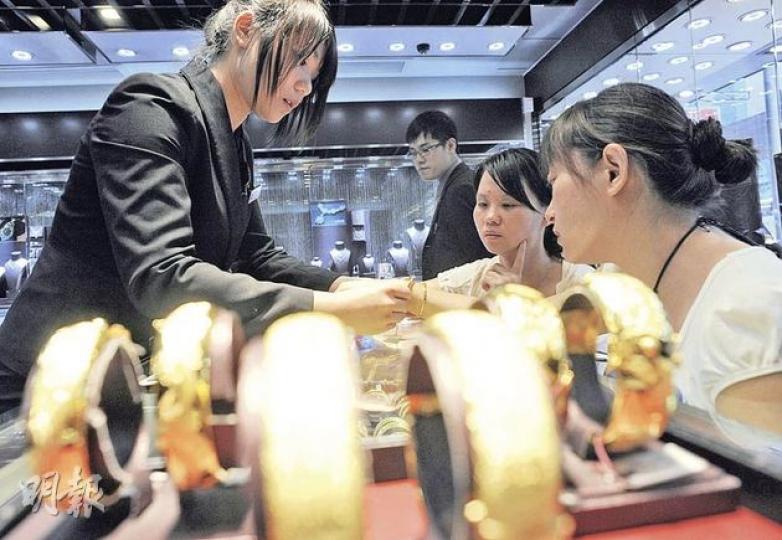 在廣州一間銀行工作的準新娘張小姐，特地請假來港挑選龍鳳鐲。被問到金價急升會不會令她猶疑時，她說：「我不在乎價錢，看中了就會買。」不過，因堅信買樓更抵，目前她仍無買金打算。而從湖南來的李女士（中），則是為慶祝婆婆60高壽來港挑金鐲，她說：「沒有想到會升得那麼快，但這個（鐲子）怎麼說都要買的，也沒法考慮價錢了。」（余俊亮攝）金粒每顆重一両，必須以現金買賣，因此目前仍以500克金條最受買家捧場。（余俊亮攝）