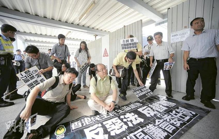 民協昨往添馬艦新政府總部請願,警方初時只容許他們在對出行人天橋示威,不許接近總部正門。立法會議員馮檢基(前左二)非常不滿,一度和民協成員坐在天橋和政府總部連接的公務員臨時出入口。(余俊亮攝) 民協昨往添馬艦新政府總部請願,警方初時只容許他們在對出行人天橋示威,不許接近總部正門。立法會議員馮檢基(前左二)非常不滿,一度和民協成員坐在天橋和政府總部連接的公務員臨時出入口。(余俊亮攝)