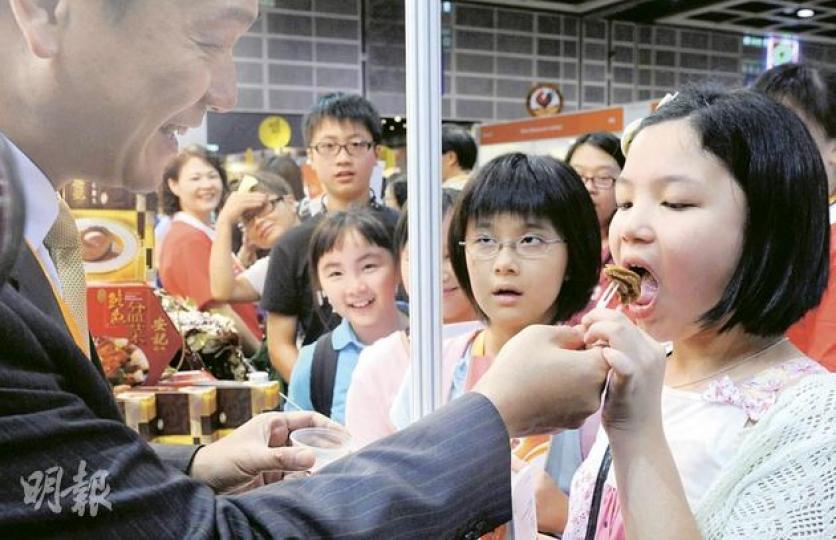 安記海味總經理潘權輝(左),昨早在美食博覽免費派發逾1000隻價值40元的罐頭鮑魚,吸引逾百人輪候。(劉焌陶攝)(明報製圖) 安記海味總經理潘權輝(左),昨早在美食博覽免費派發逾1000隻價值40元的罐頭鮑魚,吸引逾百人輪候。(劉焌陶攝)(明報製圖)