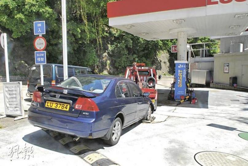 私家車撞向加油機機側,車頭損毁漏油,事後被拖走調查。(何朝財攝) 私家車撞向加油機機側,車頭損毁漏油,事後被拖走調查。(何朝財攝)